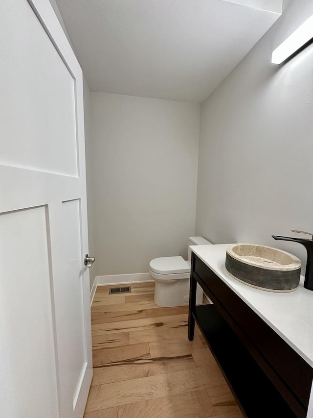 302 S 7th Ave, Maywood, IL 60153 - half bath featuring wood finished floors, toilet, vanity, and baseboards