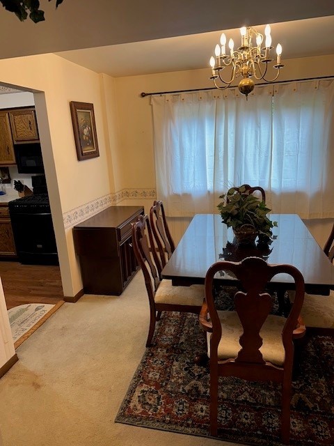 3806 Juniper Ave, Joliet, IL 60431 - dining space with light carpet, a chandelier, and baseboards