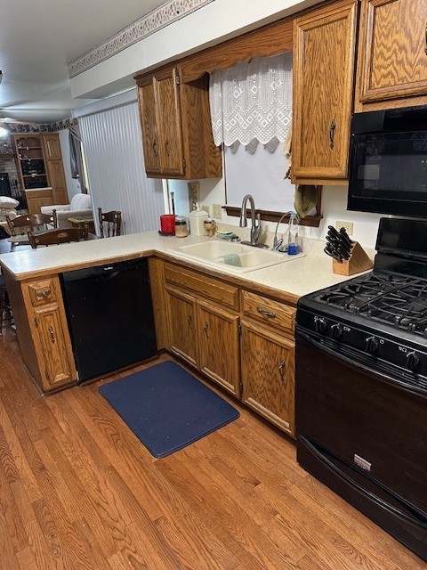 3806 Juniper Ave, Joliet, IL 60431 - kitchen with black appliances, a sink, a peninsula, and light countertops