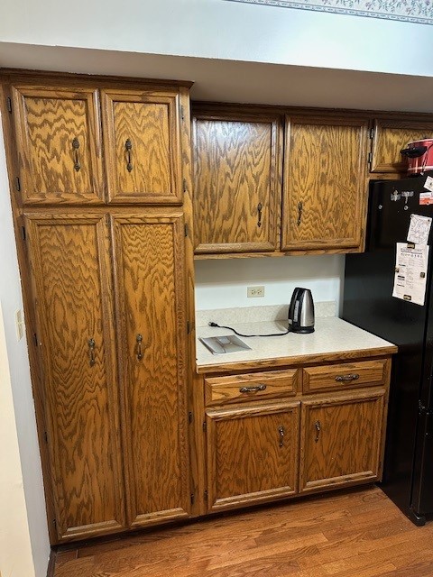 3806 Juniper Ave, Joliet, IL 60431 - kitchen featuring freestanding refrigerator, wood finished floors, light countertops, and brown cabinetry