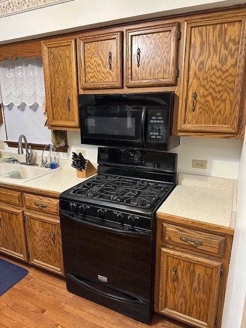 3806 Juniper Ave, Joliet, IL 60431 - kitchen with black appliances, a sink, brown cabinets, and light countertops
