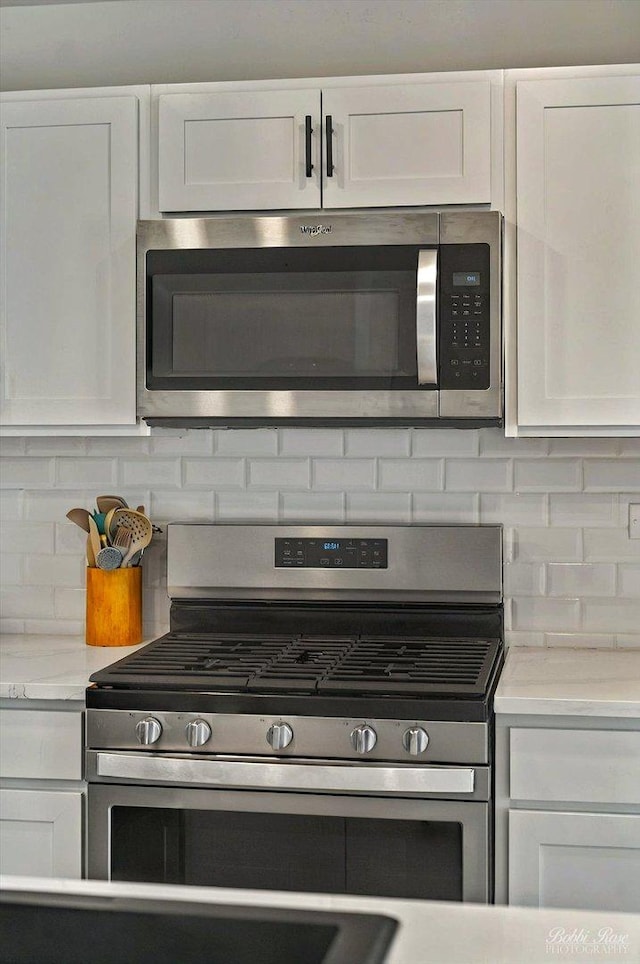 2451 Alison Ave, Pingree Grove, IL 60140 - kitchen featuring appliances with stainless steel finishes, decorative backsplash, white cabinetry, and light countertops
