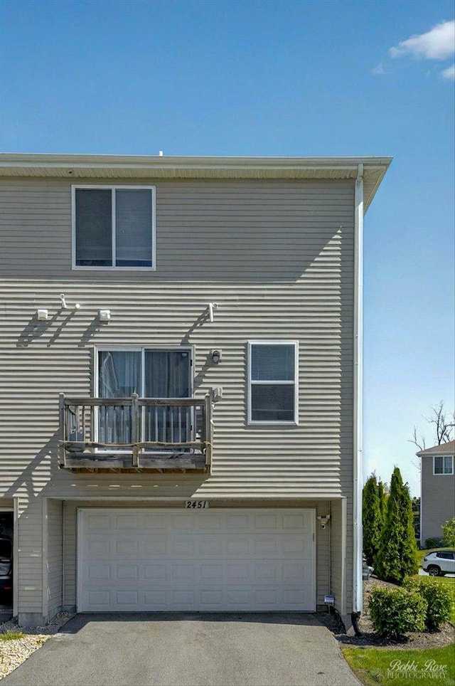 2451 Alison Ave, Pingree Grove, IL 60140 - back of house featuring a balcony, an attached garage, and driveway