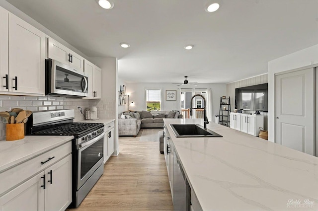 2451 Alison Ave, Pingree Grove, IL 60140 - kitchen with stainless steel appliances, a sink, a ceiling fan, white cabinetry, and light stone counters