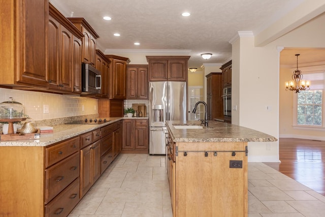kitchen featuring appliances with stainless steel finishes, a sink, ornamental molding, decorative backsplash, and a chandelier