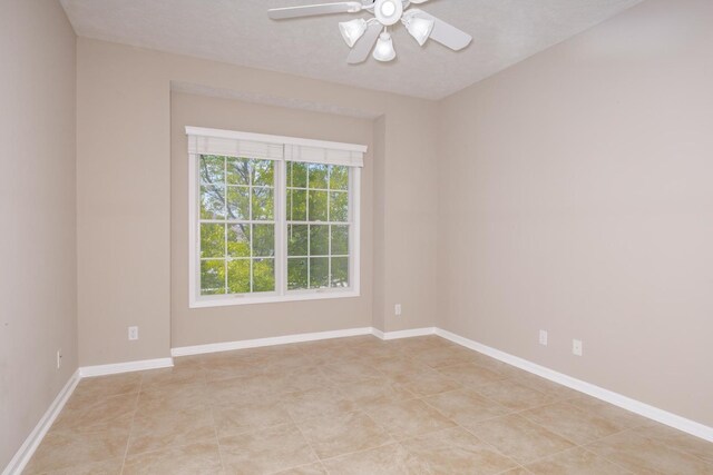 empty room featuring a ceiling fan and baseboards
