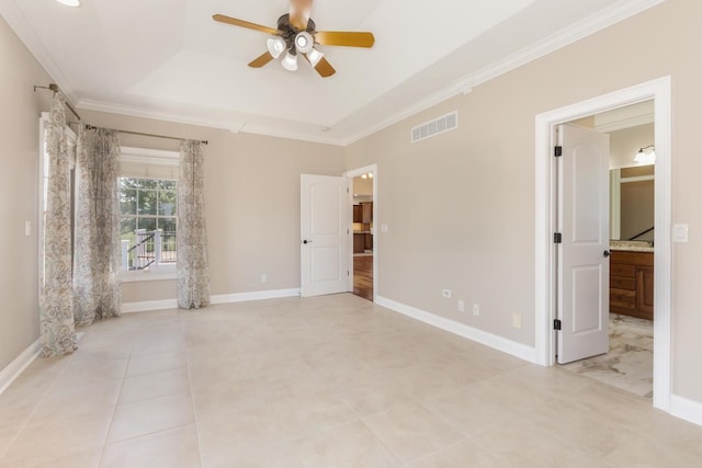 unfurnished bedroom with a tray ceiling, ornamental molding, light tile patterned floors, ensuite bath, and baseboards
