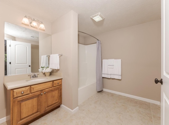 full bath with vanity, shower / tub combo, baseboards, tile patterned flooring, and a textured ceiling