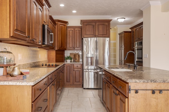 kitchen featuring appliances with stainless steel finishes, a sink, backsplash, crown molding, and a center island with sink