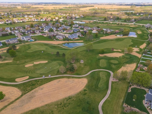 view of property location featuring a large body of water, nearby suburban area, and a local golf course