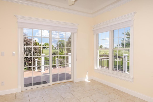 doorway to outside with crown molding, healthy amount of natural light, baseboards, and tile patterned flooring