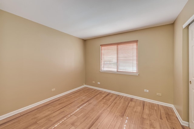 unfurnished room with light wood-type flooring and baseboards