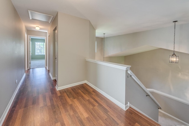 corridor with an upstairs landing, dark wood finished floors, and baseboards