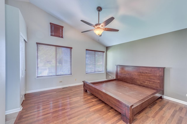 bedroom with vaulted ceiling, wood finished floors, baseboards, and a ceiling fan
