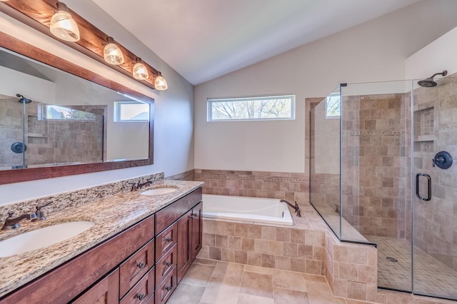 bathroom with a stall shower, lofted ceiling, a garden tub, and double vanity