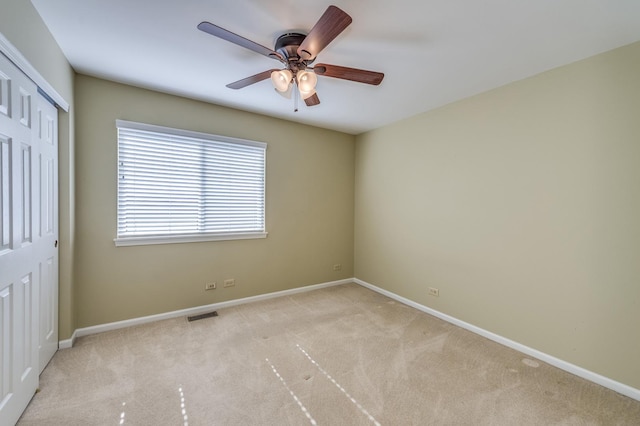 carpeted spare room with baseboards and ceiling fan