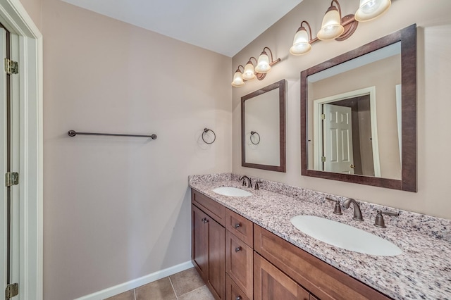 bathroom featuring double vanity, baseboards, and tile patterned flooring