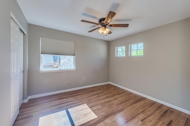 spare room with wood finished floors, baseboards, and ceiling fan