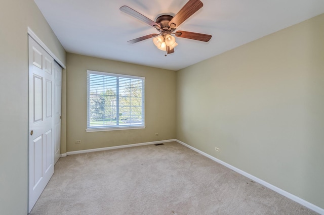 unfurnished bedroom featuring carpet flooring, baseboards, a closet, and ceiling fan
