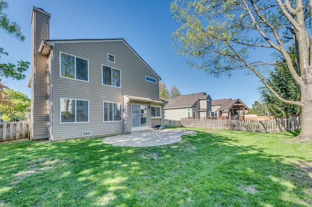 rear view of house with a chimney and a patio area