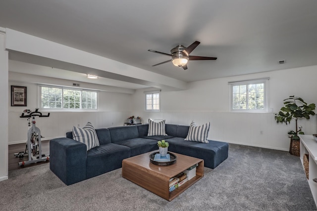 carpeted living room with wainscoting and a ceiling fan
