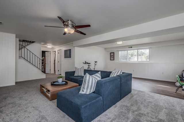 living room with stairway, a ceiling fan, carpet, baseboards, and wood finished floors