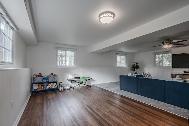 living room featuring a wainscoted wall, wood finished floors, and a ceiling fan