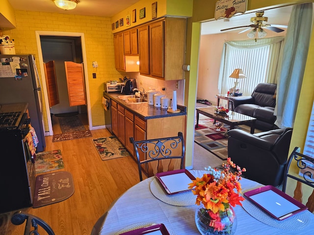 760 Mendocino Ct Unit 5, University Park, IL 60484 - kitchen featuring stainless steel range with gas cooktop, a sink, brown cabinetry, a ceiling fan, and light wood-style floors