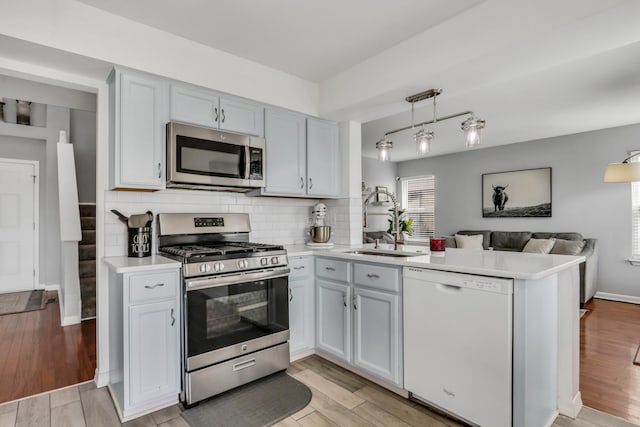 646 E Weston Ct, Round Lake Beach, IL 60073 - kitchen featuring stainless steel appliances, a peninsula, light countertops, and open floor plan
