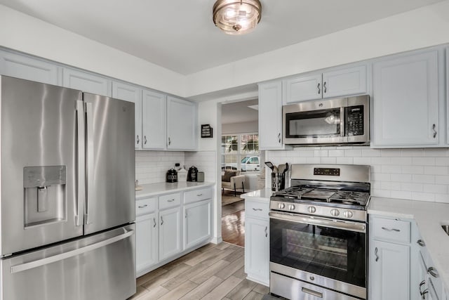 646 E Weston Ct, Round Lake Beach, IL 60073 - kitchen with appliances with stainless steel finishes, light countertops, light wood-style flooring, and decorative backsplash