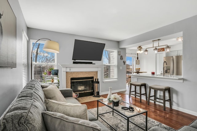 646 E Weston Ct, Round Lake Beach, IL 60073 - living room with dark wood-style floors, a fireplace with flush hearth, healthy amount of natural light, and baseboards