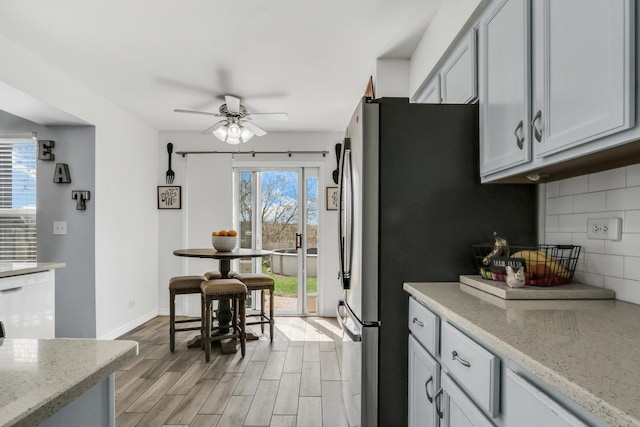 646 E Weston Ct, Round Lake Beach, IL 60073 - kitchen featuring decorative backsplash, light wood-style flooring, a ceiling fan, light stone countertops, and dishwasher