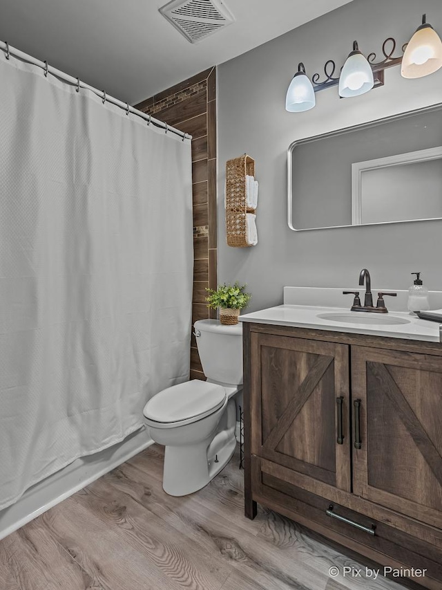 1140 Division St, Geneva, IL 60134 - full bath featuring wood finished floors, toilet, vanity, and shower / bath combination with curtain