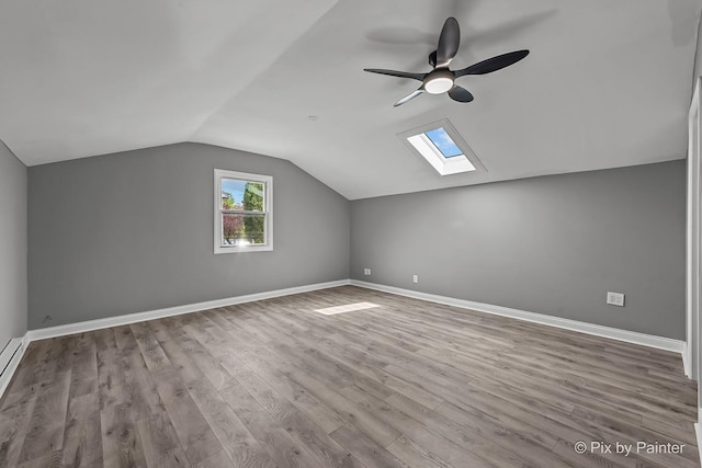 1140 Division St, Geneva, IL 60134 - additional living space featuring a ceiling fan, vaulted ceiling, a skylight, wood finished floors, and baseboards