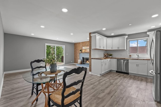 1140 Division St, Geneva, IL 60134 - kitchen featuring stainless steel appliances, recessed lighting, backsplash, a sink, and light wood-style flooring