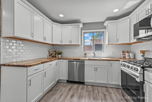 1140 Division St, Geneva, IL 60134 - kitchen with wood counters, appliances with stainless steel finishes, white cabinets, backsplash, and recessed lighting