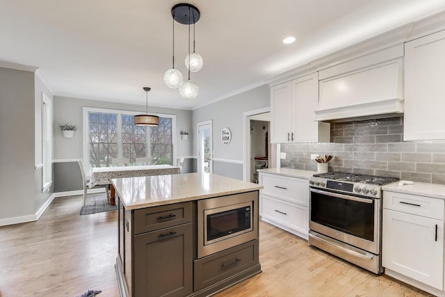 kitchen with appliances with stainless steel finishes, crown molding, tasteful backsplash, white cabinetry, and pendant lighting