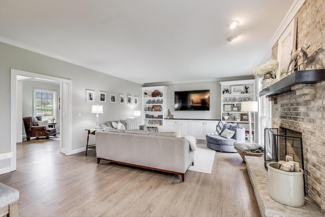 living room featuring wood finished floors, a fireplace, built in shelves, baseboards, and crown molding