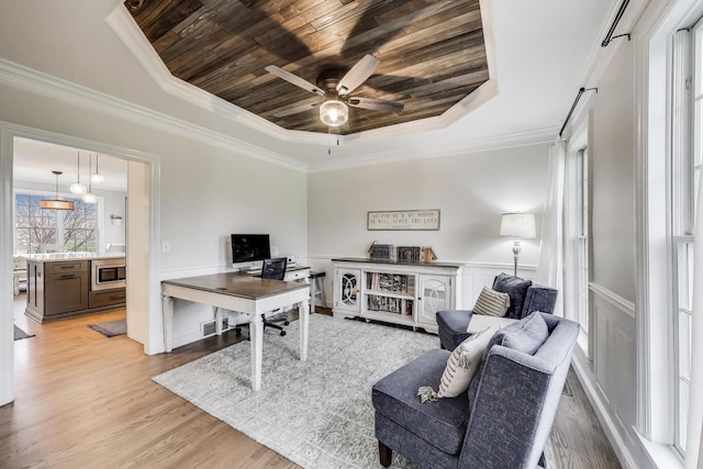living room featuring a raised ceiling, wooden ceiling, ceiling fan, light wood-style flooring, and ornamental molding