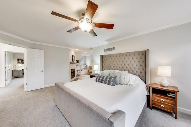 bedroom featuring ornamental molding, light colored carpet, baseboards, ceiling fan, and a fireplace
