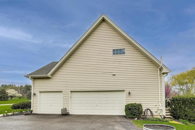 view of property exterior featuring a garage and driveway