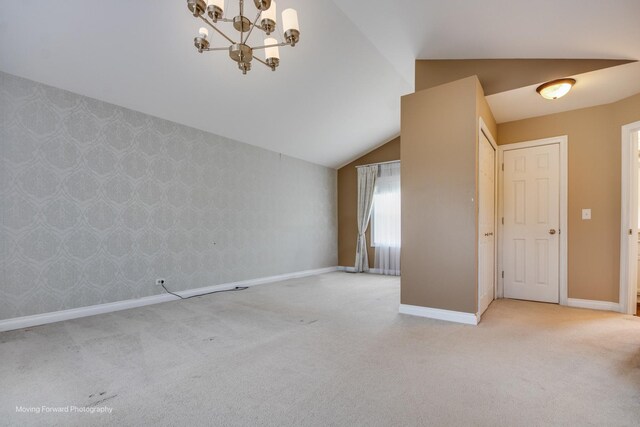 1770 Oxford Dr, Mundelein, IL 60060 - empty room featuring carpet, lofted ceiling, baseboards, a chandelier, and wallpapered walls