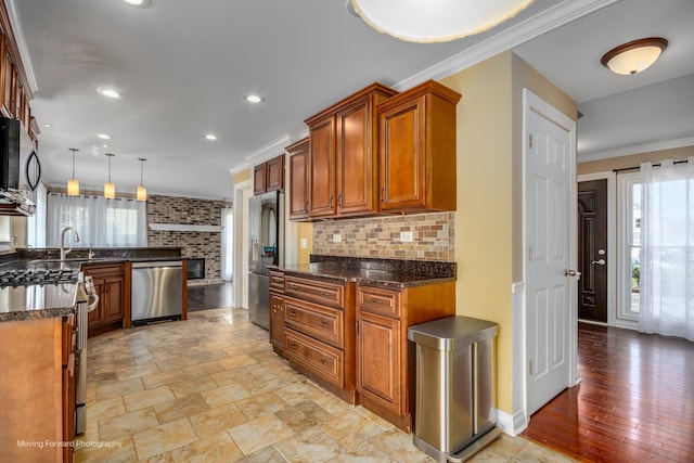 1770 Oxford Dr, Mundelein, IL 60060 - kitchen featuring appliances with stainless steel finishes, brown cabinetry, ornamental molding, a peninsula, and decorative backsplash