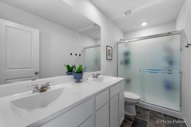 full bath featuring a stall shower, toilet, double vanity, and recessed lighting