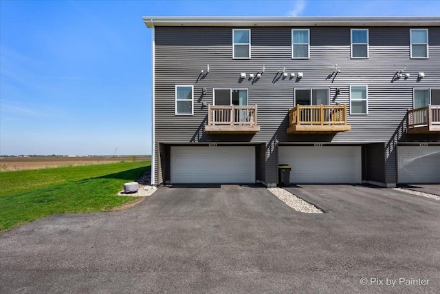 back of house with a garage and driveway