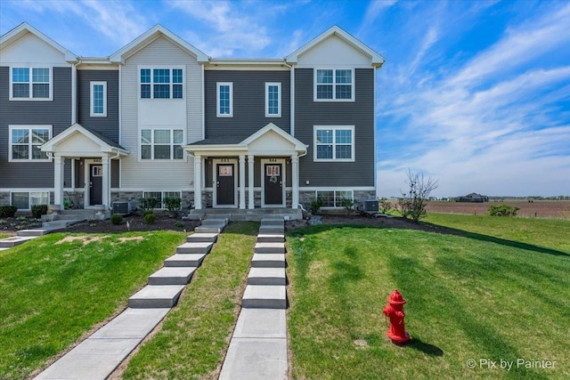 view of front of house with stone siding, a front lawn, and central AC unit