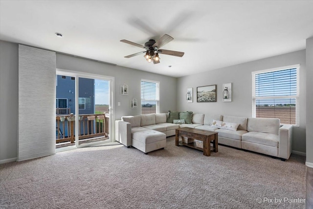 living room with a ceiling fan, carpet flooring, and baseboards