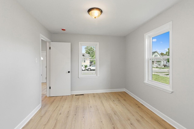 unfurnished room with light wood-style flooring and baseboards