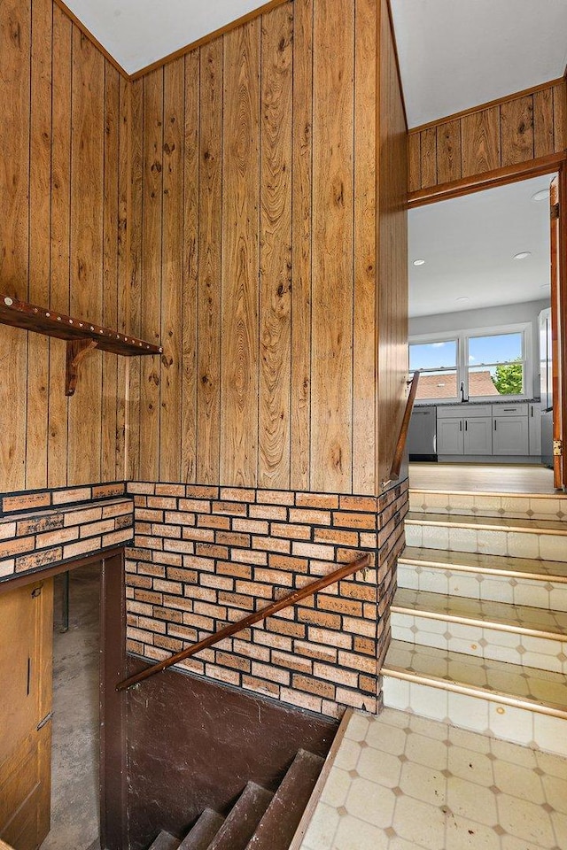 stairs featuring wooden walls and tile patterned floors
