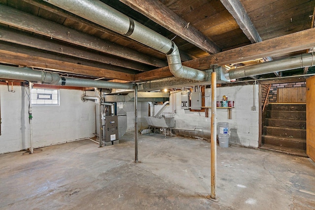 below grade area with electric panel, stairs, heating unit, and a sink